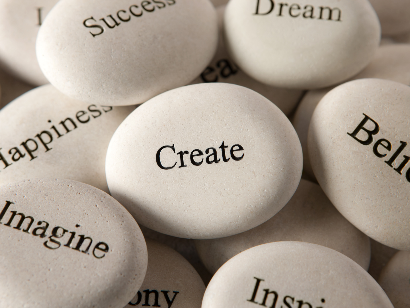 A collection of small white oval shapes with inspirational words written on them in black text